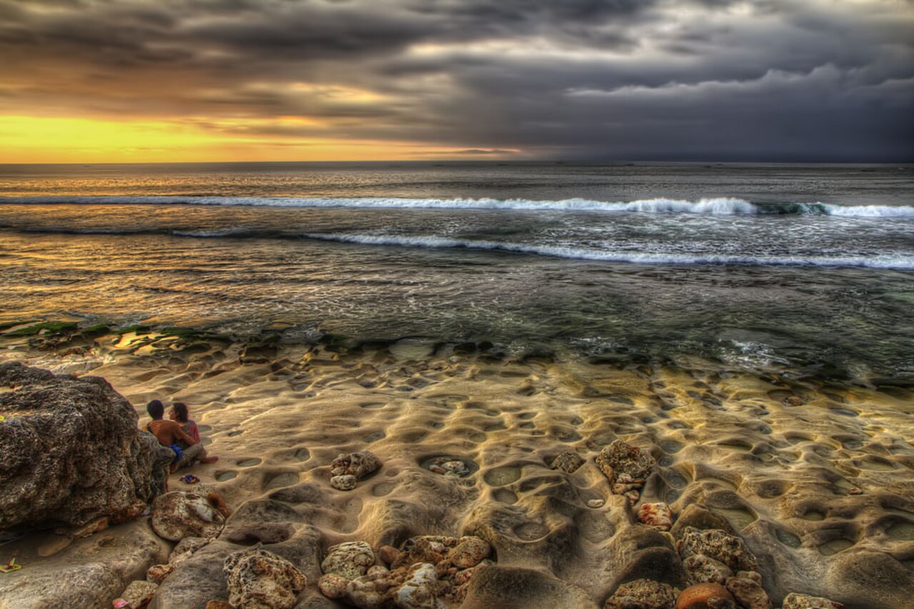 Romantic couple during a bali sunset (7590461584).jpg